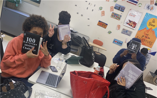 4 students holding up their savings binders